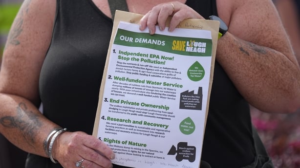A person holds a pamphlet of demands at a rally for Lough Neagh