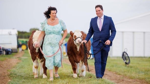 National Ploughing Championships Managing Director Anna May McHugh and Minister for Agriculture Martin Heydon walk two cows on a lease.