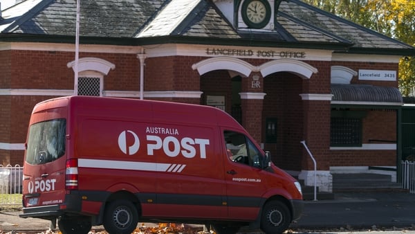 A red Postal service parked outside a rural Australian post office