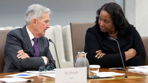 A man and a woman hacing a conversation at a board room table
