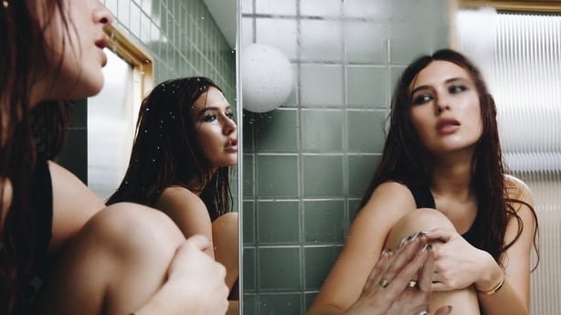 Mimi Webb looks in a mirror in a promotional photo