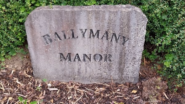 A stone sign with the words ballymany manor engraved on it