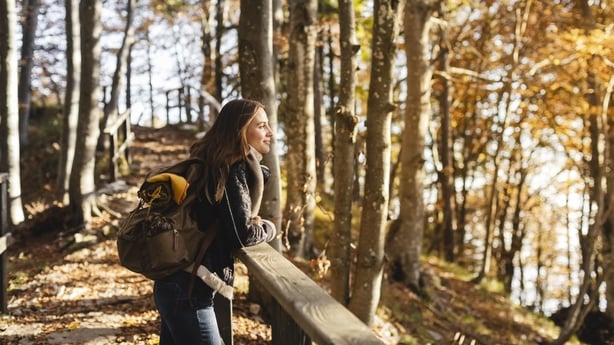 Hiker young woman enjoying the autumn forest