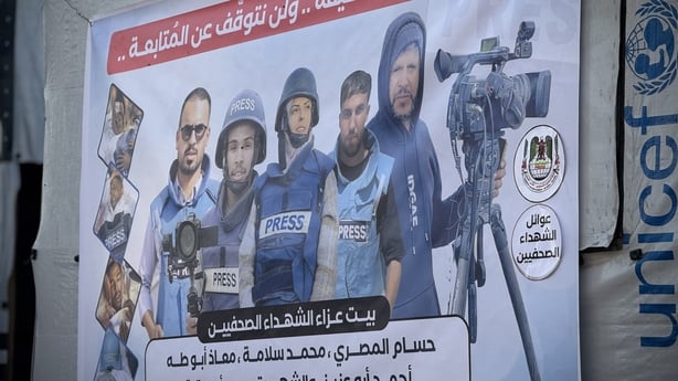 A posted on a wall in Gaza shows five people wearing vests which read 'press'