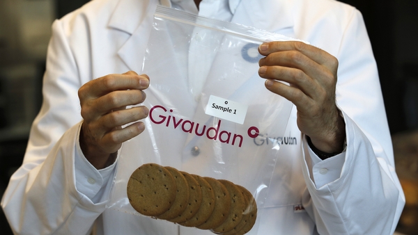 A lab technician inspects a plastic bag with the Givauan logo containing biscuit samples (Getty)