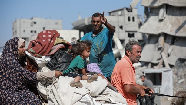A Palestinian family evacuating Gaza city on a cart with their belongings