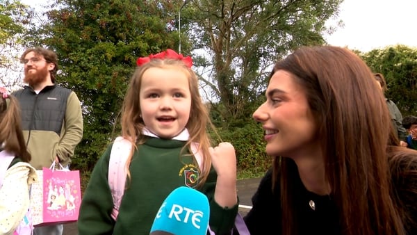 Child with her mother being interviewed on the first day of primary school