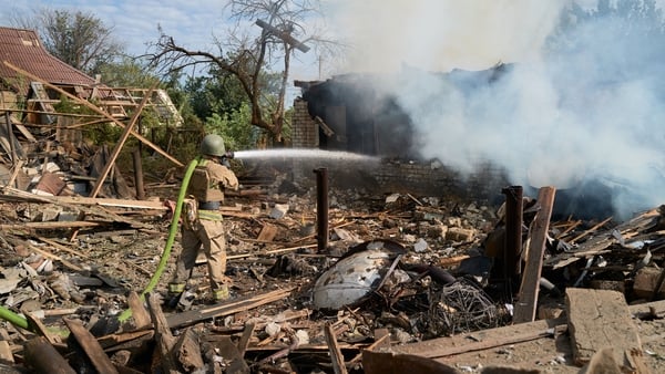 A firefighter extinguishes a burning house following a random Russian Shahed drone strike on a house near the frontline on 26 August 2025, in Iverske, Ukraine