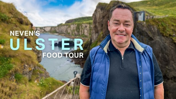 Neven Maguire stands on a rope bridge in front of a grass covered cliff. Neven's Ulster Food Trail hero