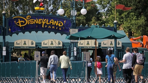 People with annual passes wearing protective face masks arrive to visit Disneyland Paris on July 13, 2020
