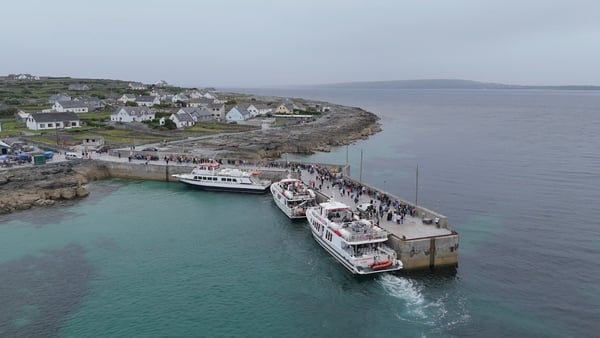 Aerial view of boats on Inis Oírr pier with the blue water and grey sky taking most of the fram
