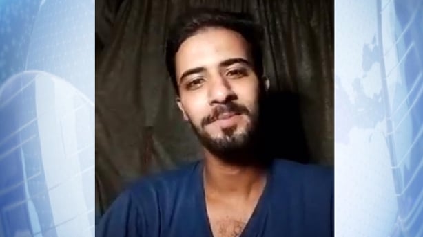 A close up of Asem Al Jerjawi who is speaking on facetime on a blue background