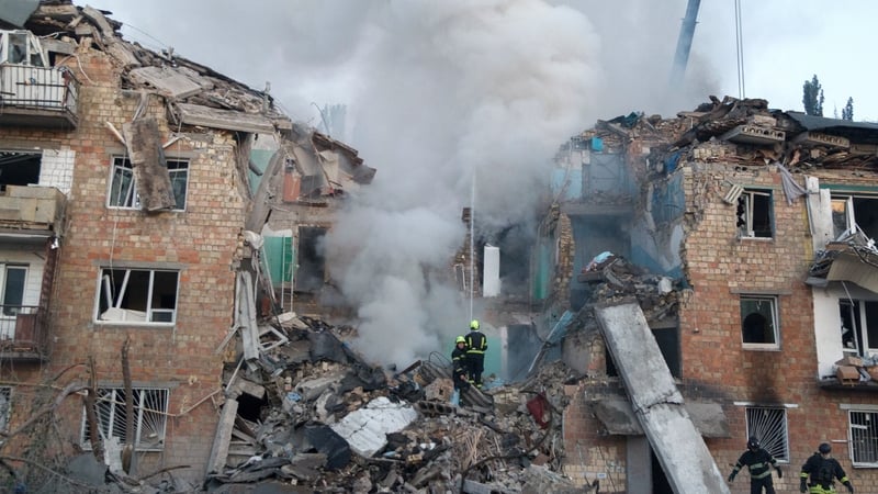 Rescuers are seen at a residential building in the Darnytskyi district following this morning's strikes