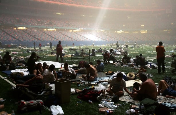 Light streaming down through the ceiling of the Superdome in New Orleans, Louisiana illuminating people taking shelter