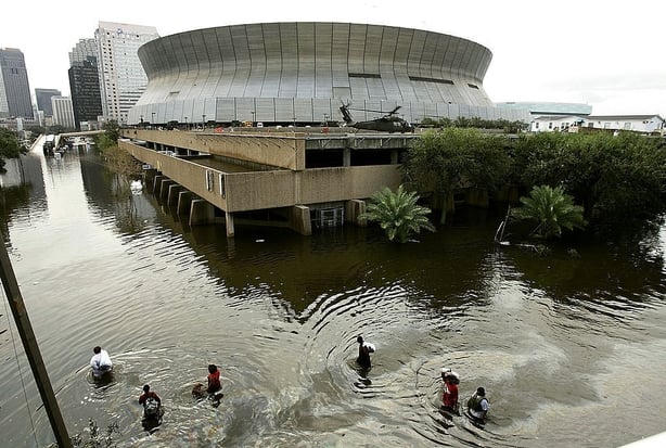 People walk through high water in front of the Superdome in New Orleans, Louisiana