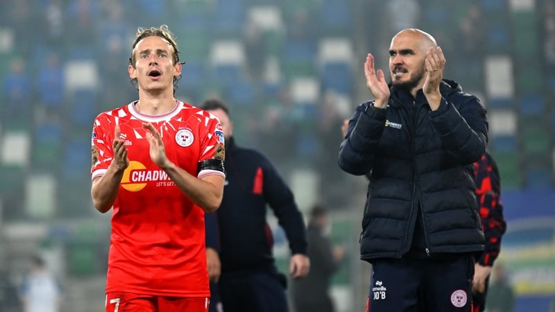 Shelbourne boss Joey O'Brien (R), with player Harry Wood, salutes the away supporters after victory at Windsor Park