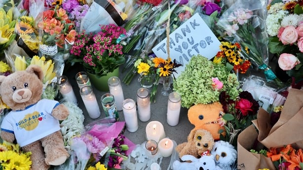 Flowers, candles and mementos are left as part of a memorial