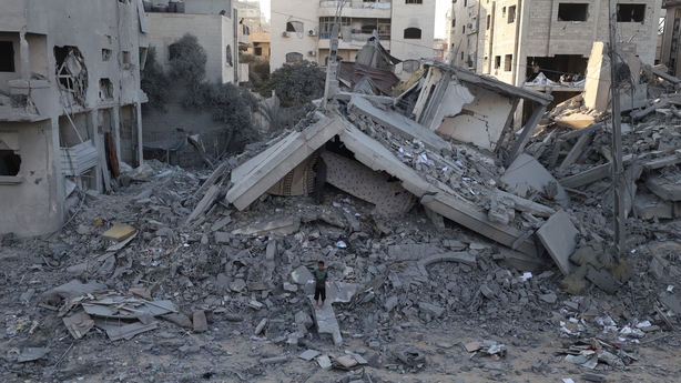 A small child is seen amid the rubble of destroyed buildings