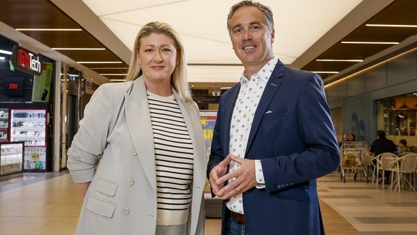Woman and a man pose for a photo in a empty shopping centre