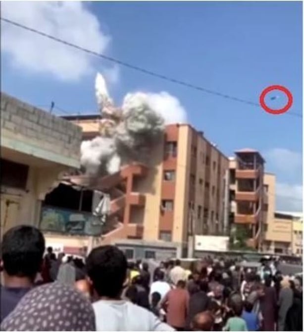 A screengrab showing a missile circled above damaged buildings