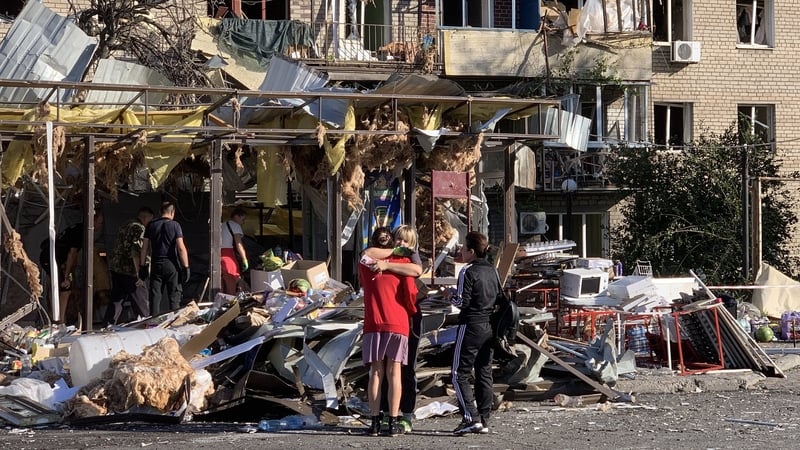 Residents are pictured next to a destroyed building in Zaporizhzhia