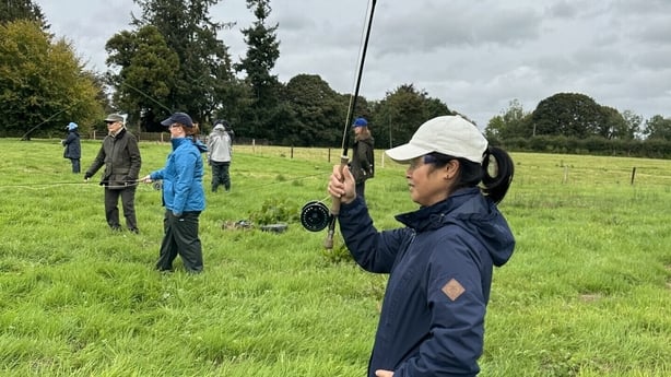 A group practicing casting on grass