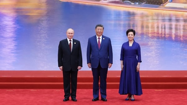 In this pool photograph distributed by the Russian state agency Sputnik, Russia's President Vladimir Putin, Chinese President Xi Jinping and his wife Peng Liyuan pose during a welcoming ceremony of the Shanghai Cooperation Organization (SCO) Summit in Tia
