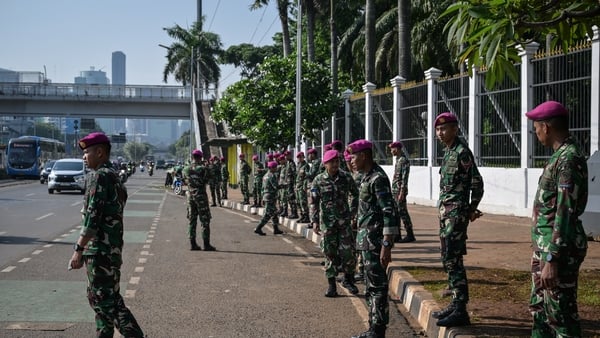 Police stand in a line at the side of the road