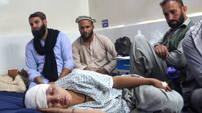 An injured Afghan boy (bottom) receives treatment at a hospital