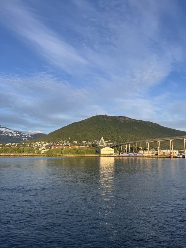 A view of a grassy mountain and a lake
