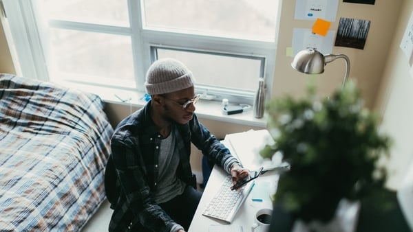 Young man working at his desk in his bedroom