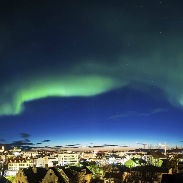 A night shot of the Northern Lights over a city