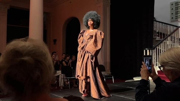 A model wearing a brown gown on a runway