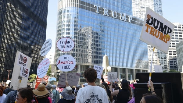 Protesters hold signs reading "Dump Trump" during a rally outside Trump Tower on Labor Day in Chicago