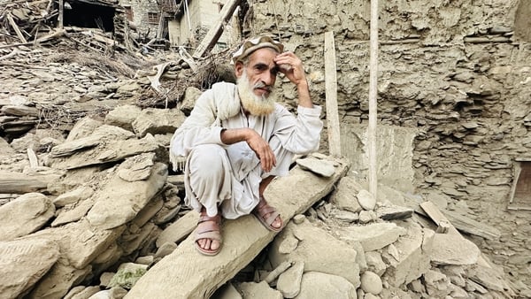 A man sits outside near severely damaged houses after a 6.0-magnitude earthquake struck Afghanistan's eastern Kunar province