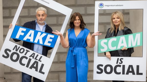 Two women and one man pose in with anti-financial fraud posters