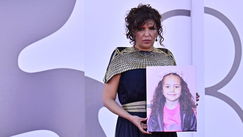 Director Kaouther Ben Hania holds a portrait of the late Palestinian girl Hind Rajab during the red carpet for her film The Voice of Hind Rajab at the Venice Film Festival