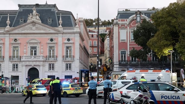 Police and firefighters work on the site of a funicular railway accident in Lisbon