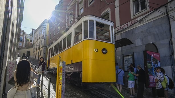 Tourists and locals queue while waiting to board the cabin of Gloria Funicular (in 2023 in Lisbon, Portugal.
