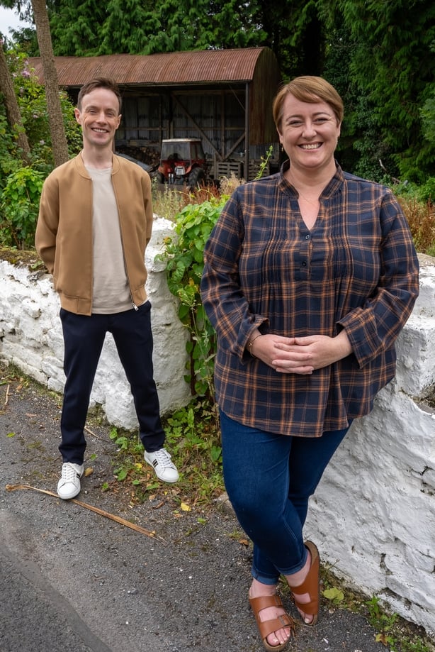 Two people stand on a country road