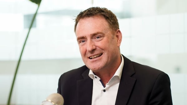 Image of a man in a suit pictured at a desk