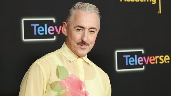 Alan Cumming poses for a photo on the red carpet