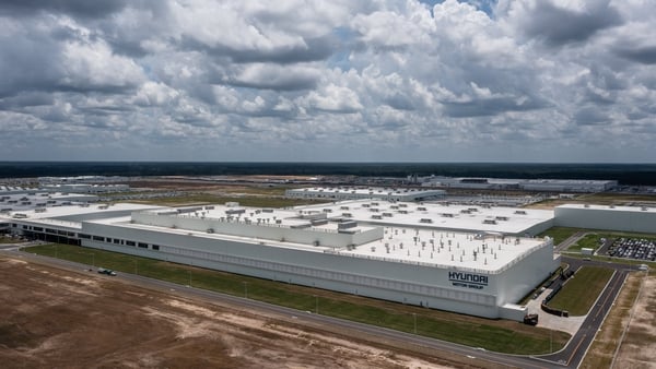 A large EV manufacturing facilty pictures against a cloudy sky