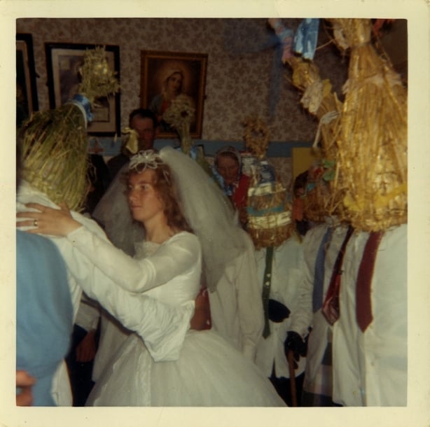 A bride dancing with a strawboy at a wedding