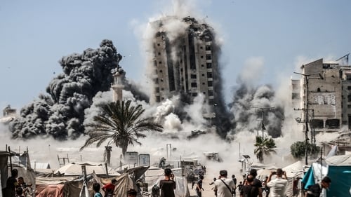 Smoke and dust rise from the Mushtaha Tower in Gaza City after it was hit by Israeli airstrikes