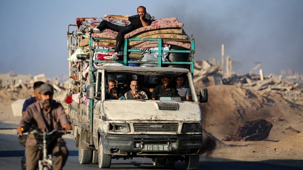 Palestinians fleeing south, ride a truck with their belongings
