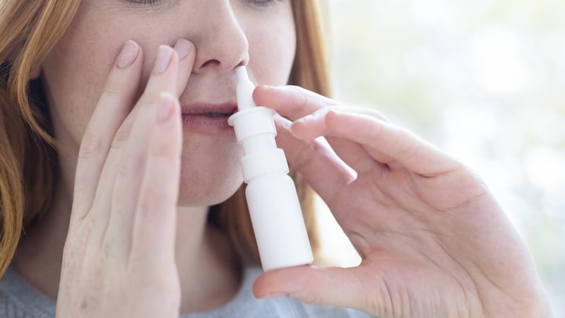 Woman using a nasal spray