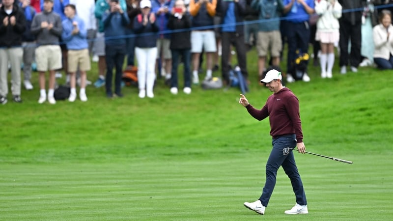 Rory McIlroy acknowledges the gallery as he walks up the 18th fairway