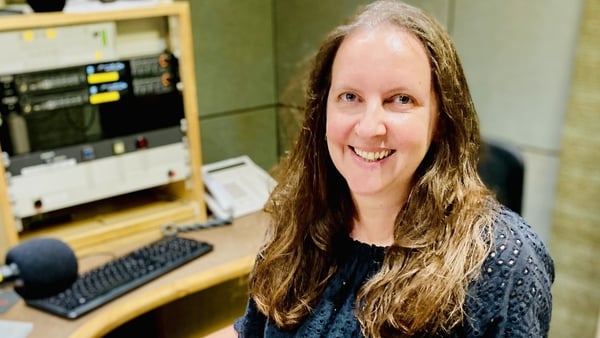writer Niamh Donnellan in an RTÉ Radio studio, behind mic and smiling towards camera, 2025