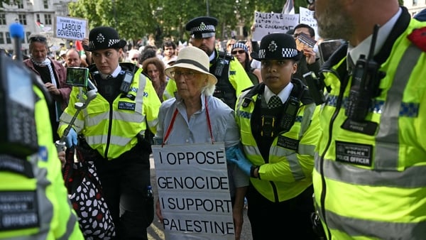 An elderly protester is taken away by police officers at a "Lift The Ban" demonstration in support of the proscribed group Palestine Action